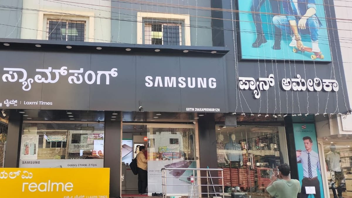 Shop fascia with the Samsung name in Kannada and English lettering and a realme board below.