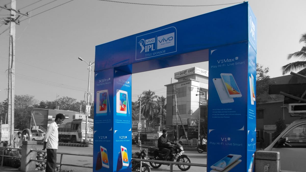 Blue Vivo IPL branded promotional entrance arch installed on a street footpath, with traffic behind.