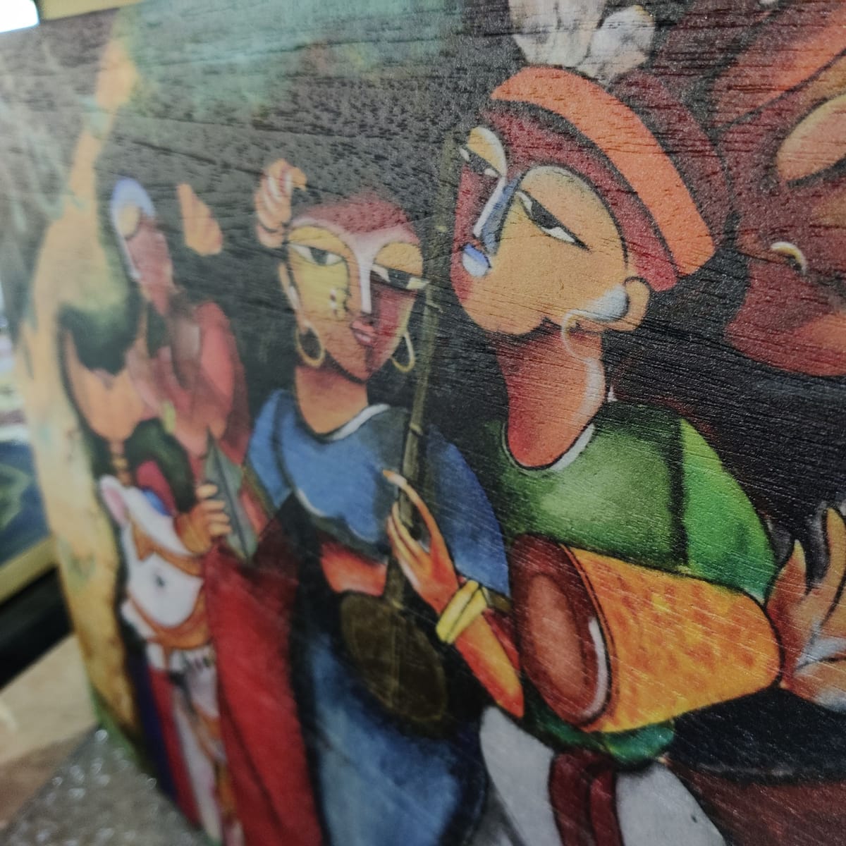 Close-up of a panel printed with folk-art figures playing instruments, wood grain visible through the ink.
