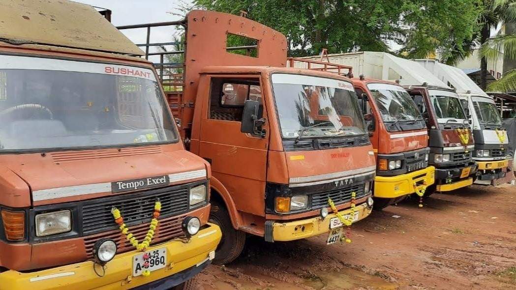 Row of orange Sushant Tata trucks in the yard