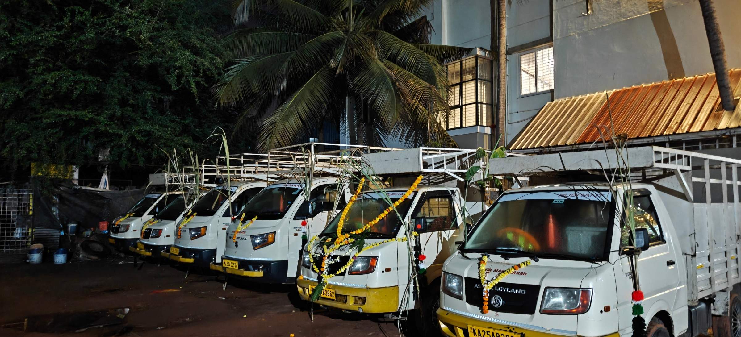 Row of small cargo pickups in the Dharwad yard