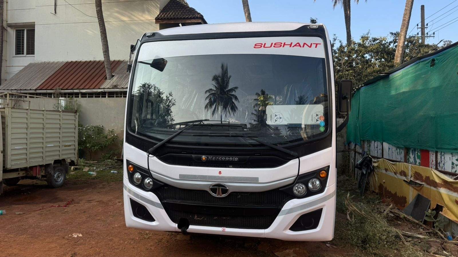 White Sushant Tata staff bus, head-on