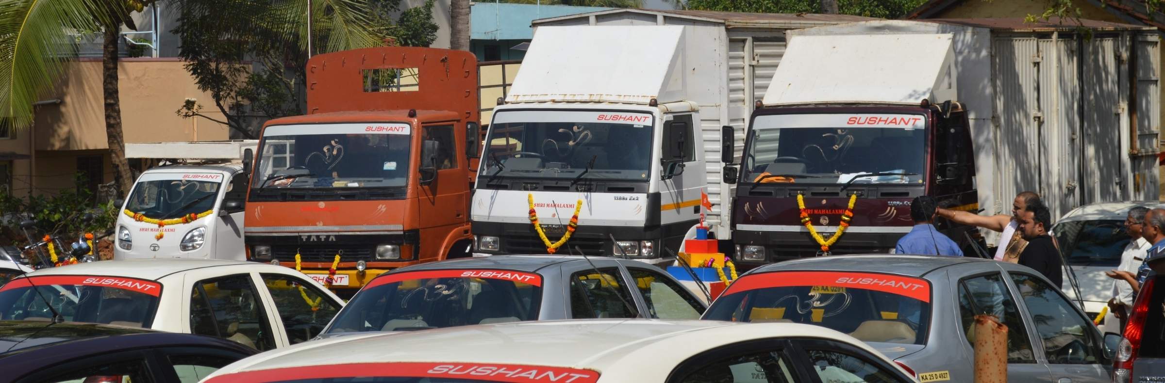 Sushant-branded trucks and taxis parked along a street