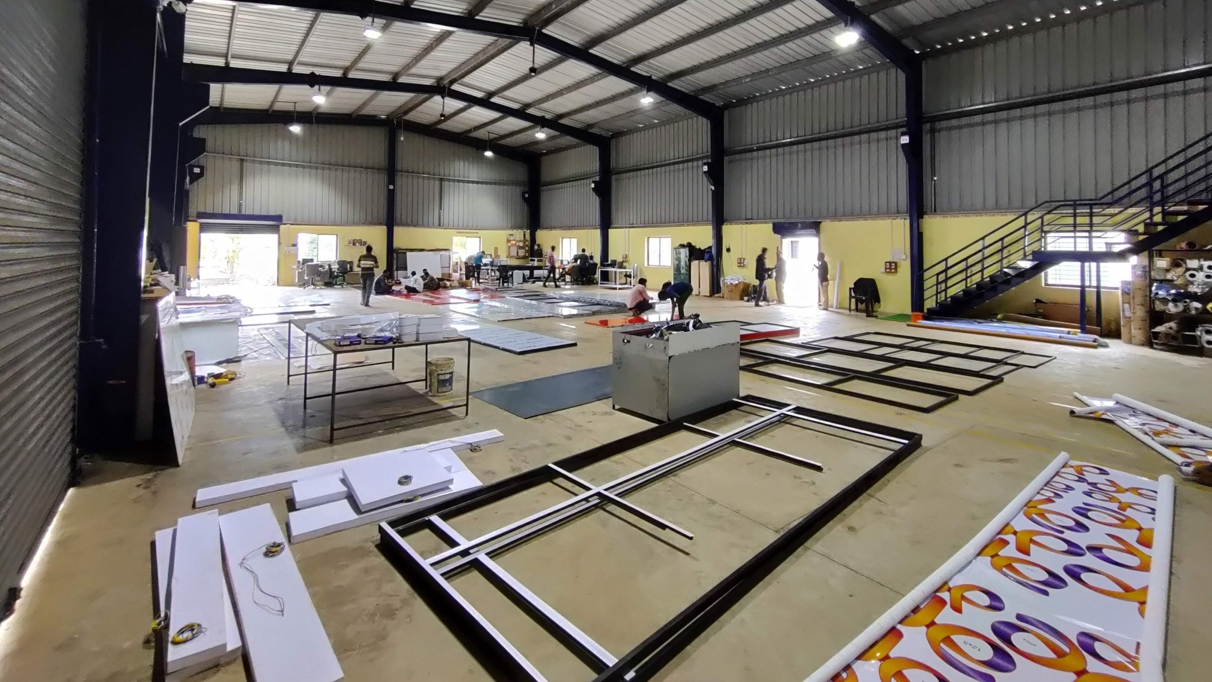 Fabrication shed with steel signage frames laid out on the floor