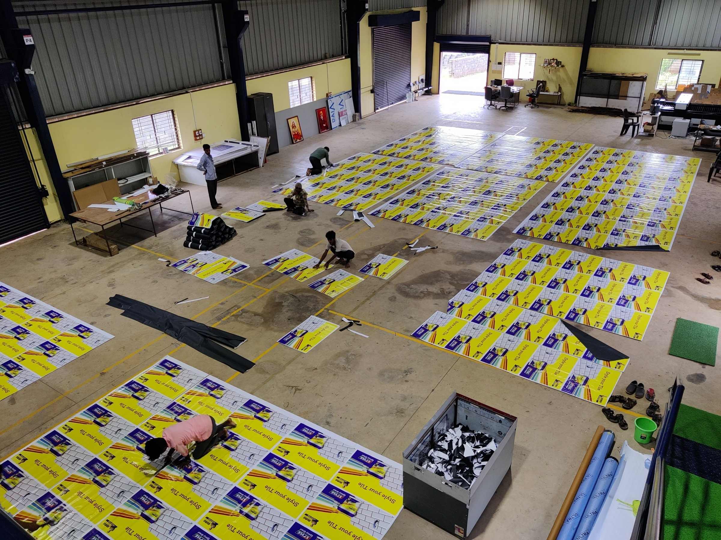 Print hall with signage panels laid out across the floor