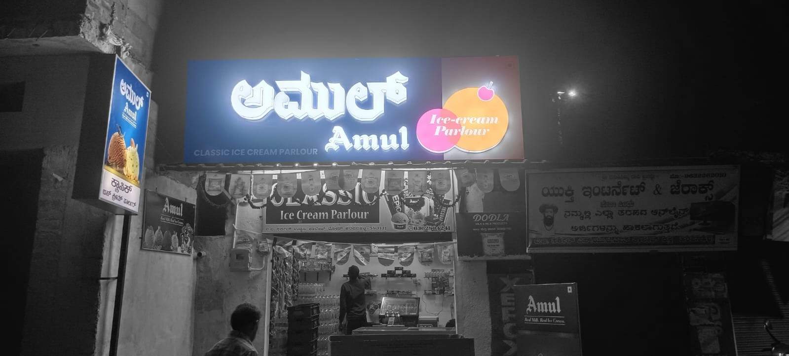 Illuminated Amul 3D built-up storefront sign at night