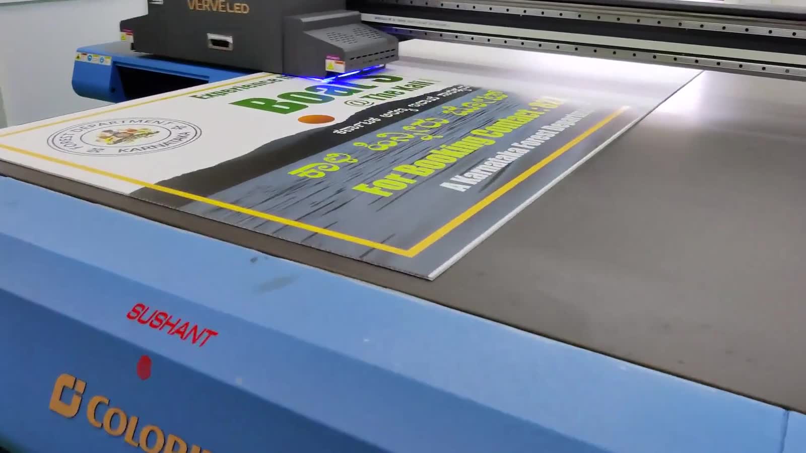 Our UV flatbed printers in Dharwad running live client work, operators at the bed.