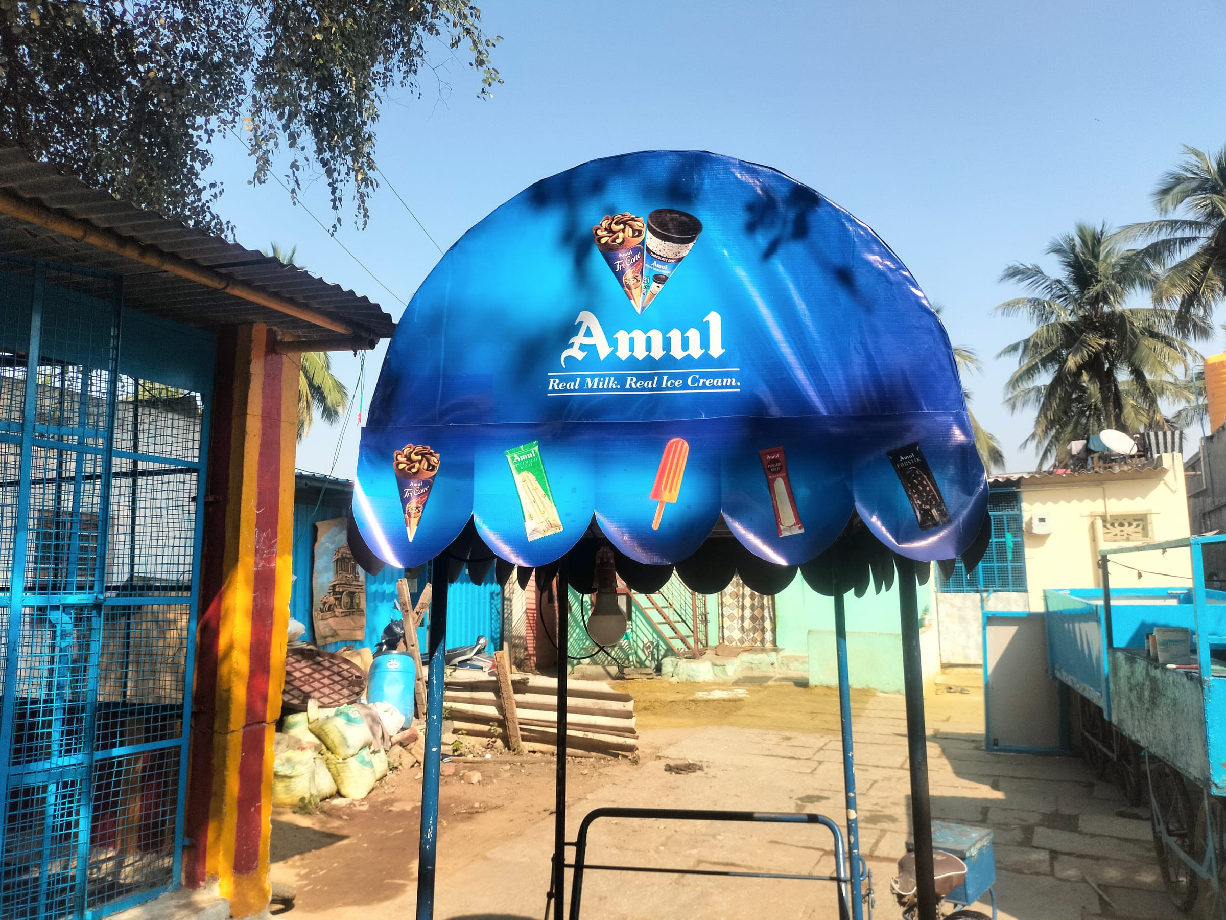 Blue Amul dome canopy over a roadside cart