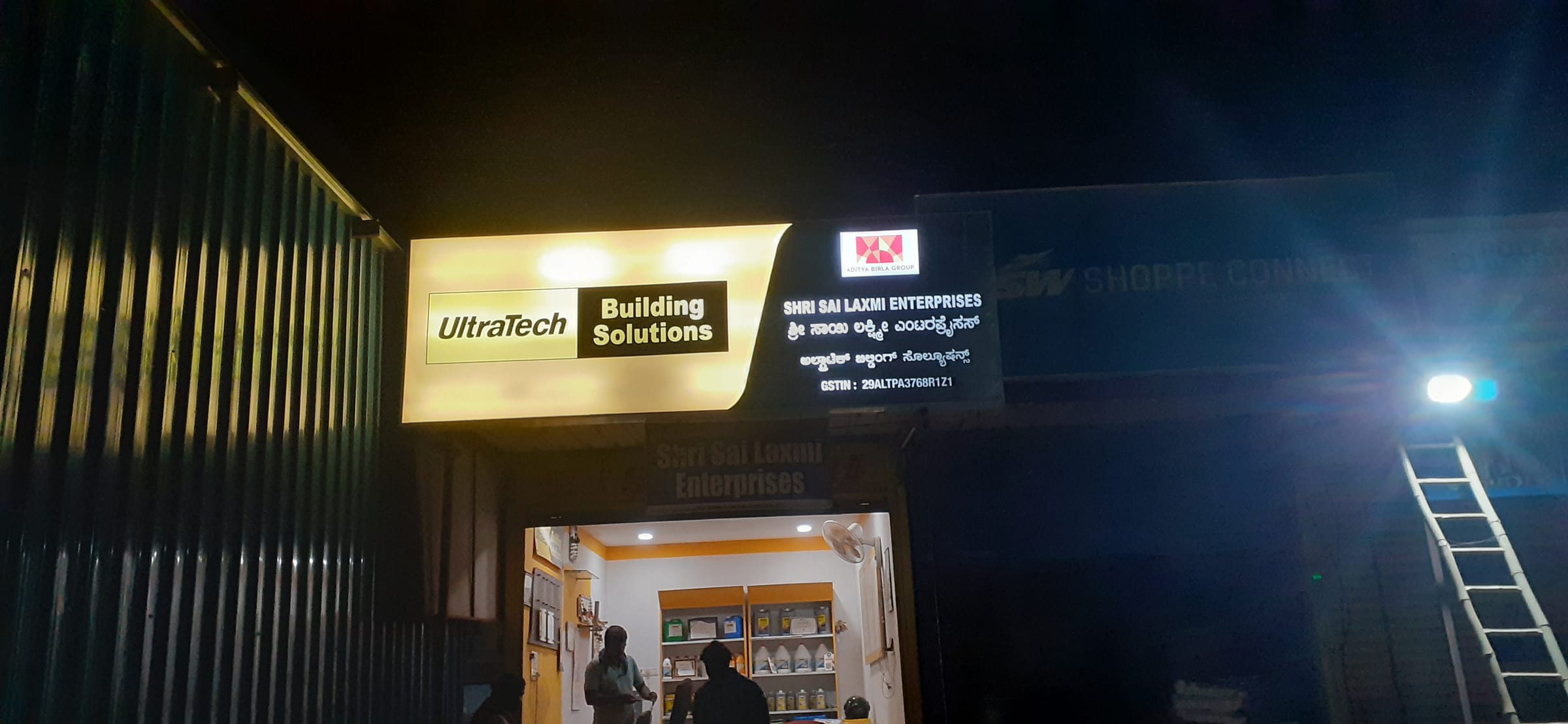 Building Solutions lightbox above a dealer's shop at night